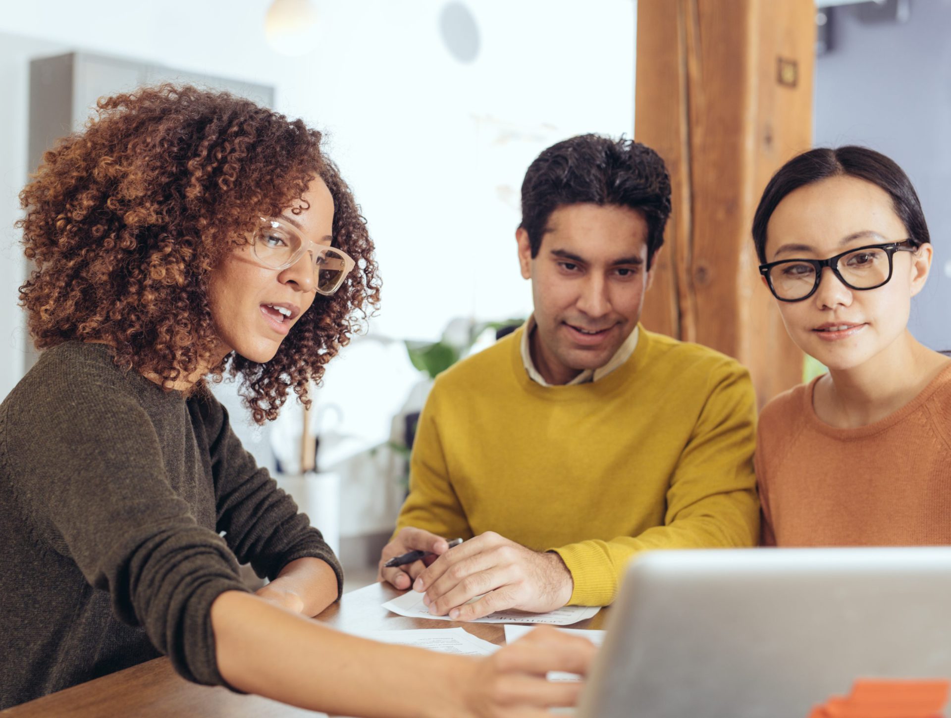 Three people looking at a laptop.